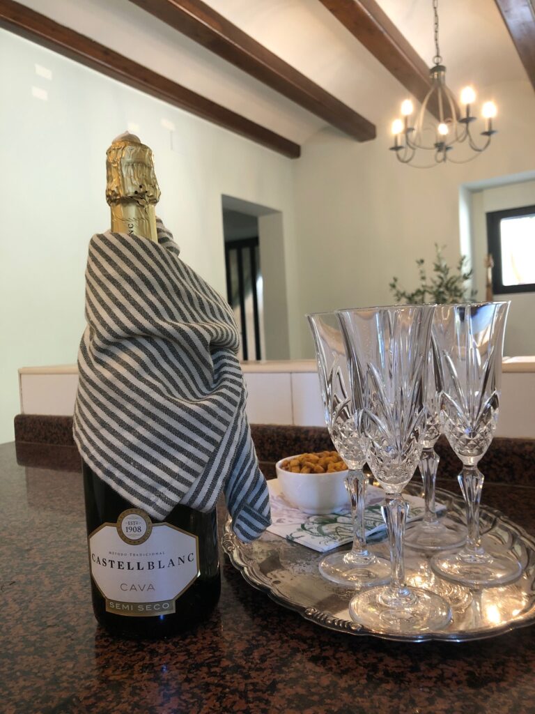 Bottle of sparkling wine with a trey of champagne glasses.