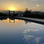 Beutiful sunset over the mountains with the swimingpool in the foreground.